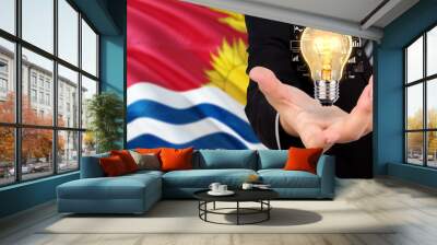 Kiribati creativity concept. Businessman with a light bulb in his hand on national background. Innovation and technology theme. Wall mural