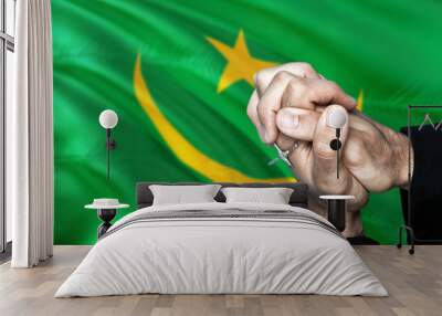 Mauritania flag and praying patriot man with crossed hands. Holding cross, hoping and wishing. Wall mural