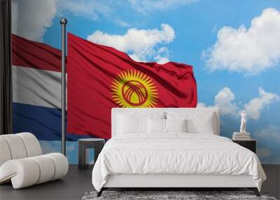 Netherlands and Kyrgyzstan flag waving in the wind against white cloudy blue sky together. Diplomacy concept, international relations. Wall mural