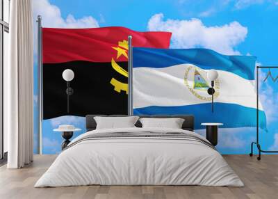 Nicaragua and Angola national flag waving in the windy deep blue sky. Diplomacy and international relations concept. Wall mural