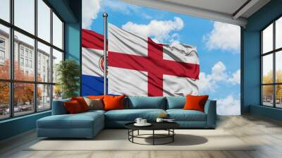 Paraguay and England flag waving in the wind against white cloudy blue sky together. Diplomacy concept, international relations. Wall mural