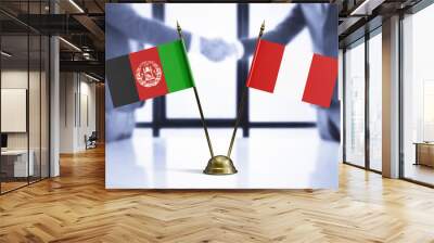 Peru and Afghanistan mini table flags on white wooden desk. Diplomatic background with men shaking hands, international relations and agreements. Wall mural