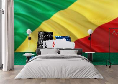 Republic Of The Congo casino theme. Two ace in poker game, cards and black chips on green table with national flag background. Gambling and betting. Wall mural