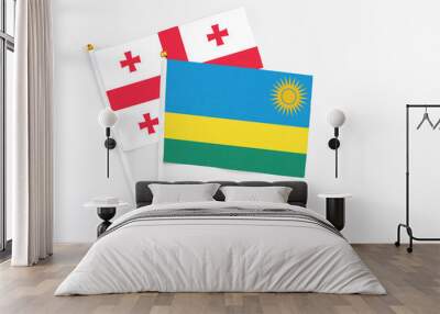 Rwanda and Georgia stick flags on white background. High quality fabric, miniature national flag. Peaceful global concept.White floor for copy space. Wall mural