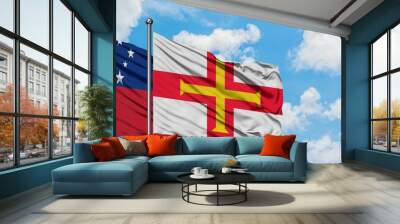 Samoa and Guernsey flag waving in the wind against white cloudy blue sky together. Diplomacy concept, international relations. Wall mural