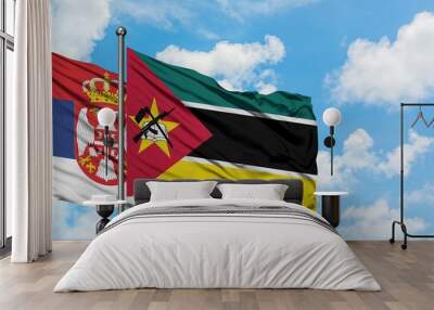 Serbia and Mozambique flag waving in the wind against white cloudy blue sky together. Diplomacy concept, international relations. Wall mural