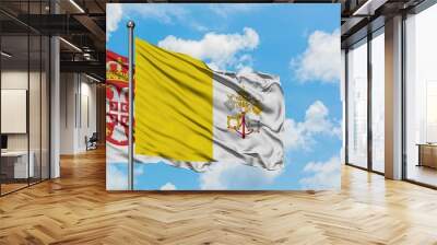 Serbia and Vatican City flag waving in the wind against white cloudy blue sky together. Diplomacy concept, international relations. Wall mural