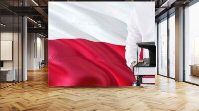 Successful Polish student education concept. Holding books and graduation cap over Poland flag background. Wall mural