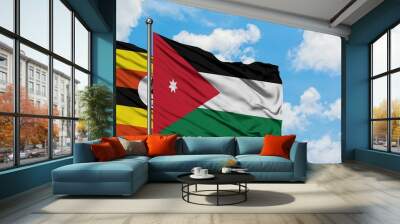 Uganda and Jordan flag waving in the wind against white cloudy blue sky together. Diplomacy concept, international relations. Wall mural