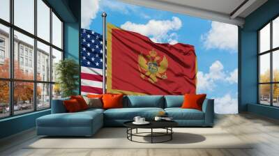 United States and Montenegro flag waving in the wind against white cloudy blue sky together. Diplomacy concept, international relations. Wall mural