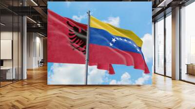 Venezuela and Albania flags waving in the wind against white cloudy blue sky together. Diplomacy concept, international relations. Wall mural