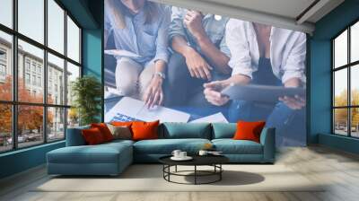 Closeup view of three young coworkers working on mobile laptop computer at office.Woman holding tablet and pointing on touch screen. Horizontal, blurred background. Wall mural