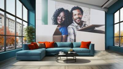 Closeup view of young black african man and his girlfriend moving boxes into new house together and making a successful life.Cheerful family standing in empty new apartment.Blurred background. Wall mural