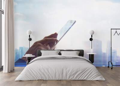 Hands with digital tablet on blurred city background Wall mural