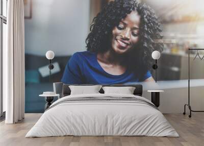 Happy young african american woman shopping online through laptop using credit card at home. Horizontal,blurred background. Wall mural