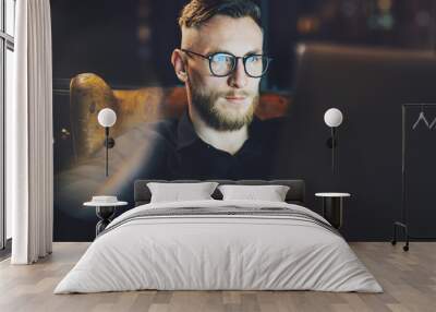 Photo stylish banker still working modern loft office after hard day. Man sitting in vintage chair at night.Using contemporary laptop, blurred background.Soft light,shadows.Horizontal,film effect.  Wall mural