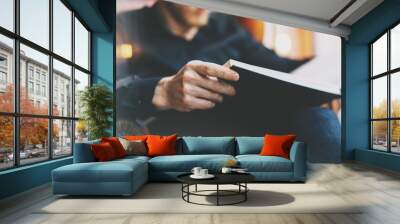 Portrait handsome bearded man wearing glasses black shirt.Man sitting in vintage chair university library, reading book and relaxing. Blurred background.Horizontal, film effect.  Wall mural