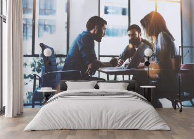 Teamwork brainstorming process.Young man working together with partners in modern office loft.Business startup concept.Blurred background.Flares. Wall mural