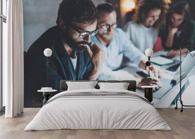 Teamwork concept.Project team making conversation at meeting room at night office.People using laptops and gadgets.Horizontal.Blurred background.Flares effect. Wall mural