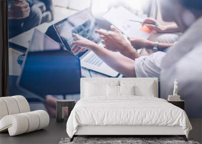 Young coworkers working on laptop computer at office.Woman holding tablet hand and pointing on touch screen. Horizontal, blurred background.Cropped. Wall mural