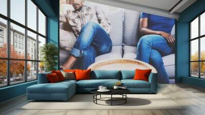 Young displeased black couple.American african men arguing with his girlfriend,who is sitting on sofa on couch next to him with legs crossed.Man looking away offended expression on her face.Cropped. Wall mural