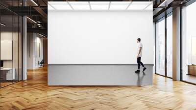 young man walking in the empty gallery Wall mural