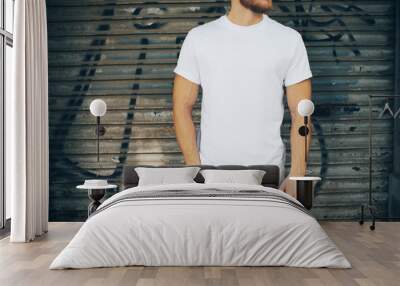 Young man wearing white blank t-shirt and blue jeans, standing Wall mural