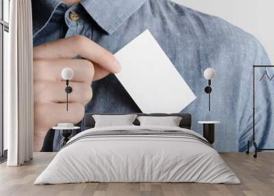 Business Card Mock-Up (85x55mm) - Man in a denim shirt holding a blank card on a gray background. Wall mural