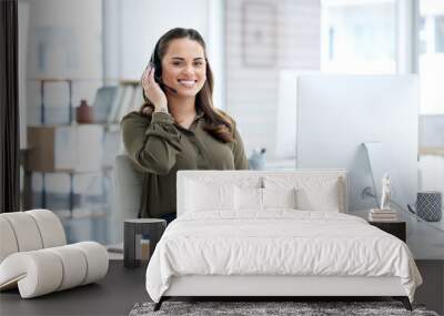 Super helpful from the first hello. Portrait of a young businesswoman using a headset and computer in a modern office. Wall mural