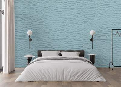 Close-up view of a textured surface with a consistent pattern. The surface appears to be a light blue color, with a slightly rough and uneven texture that resembles ripples or waves. Wall mural