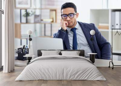 Businessman in glasses, thinking or reading on laptop in office, desk or corporate workplace with professional employee. Man, business and focus on working, planning or entrepreneur busy on computer Wall mural