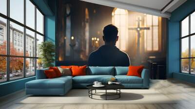 A Christian man praying inside a church with a cross in the background Wall mural