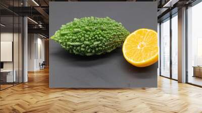 bitter melon or bitter gourd with orange isolated on black background Wall mural