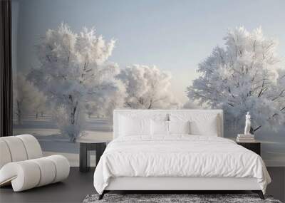 A serene winter landscape with snow-covered trees in soft white and grey tones, under a clear, pale blue sky, with gentle shadows creating a sense of calm and quiet. Wall mural