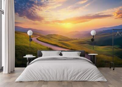 The sun dips below the horizon, casting a golden glow over a winding road in green hills. Dramatic clouds and sun rays enhance the summer landscape. Wall mural