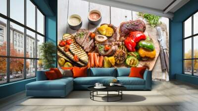 grilled vegetables and steak with herbs on white table Wall mural