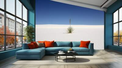 Plant in the desert with white sand and blue sky Wall mural