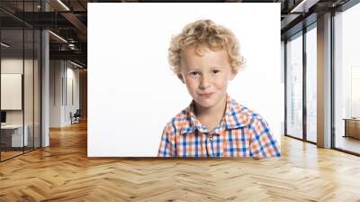 Adorable, curly haired little boy trying not to laugh, isolated on white background Wall mural