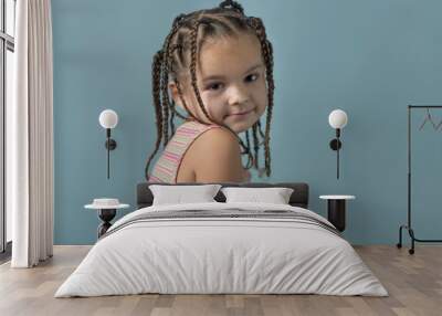 Sweet, toddler girl with braided hair on blue background Wall mural