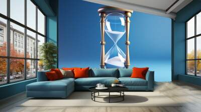 An hourglass on blue background. Concept of time passing, urgency or deadline. Wall mural