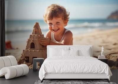 Cute and happy little boy making a sand castle by the beach. Wall mural