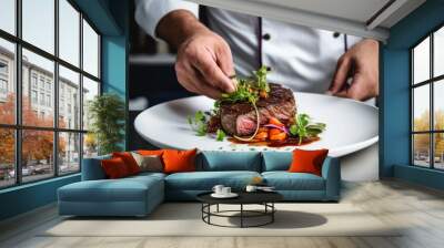  a chef is garnishing a piece of steak with a garnish on top of lettuce, carrots, and other vegetables on a white plate. Wall mural