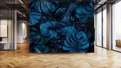   A close-up of blue flowers on a black background with a green plant in the center Wall mural