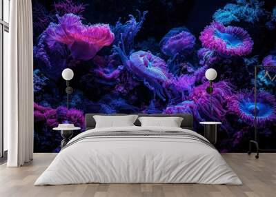   A dark blue sea with a black background features a group of purple and blue sea anemones on a coral reef Wall mural