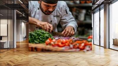   A man in a chef's hat skillfully chops onions beside a mound of veggies on a cutting board Wall mural