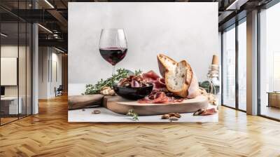  a plate of food and a glass of wine on a white tablecloth with a bottle of wine and a corkscrew next to it.  generative ai Wall mural