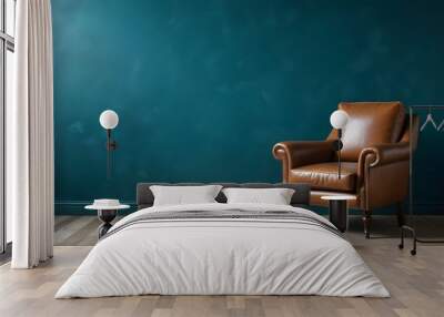 A vintage leather armchair in a room with a teal blue wall and wooden floor. Wall mural