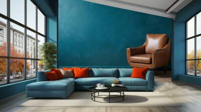 A vintage leather armchair in a room with a teal blue wall and wooden floor. Wall mural