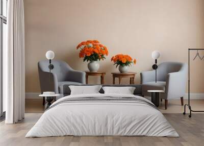 Two gray armchairs with a small wooden table between them, a vase with orange flowers on the table, against a plain beige wall background. Wall mural