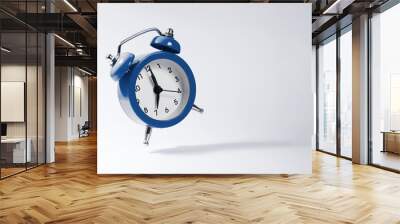 The dark blue alarm clock bounces against the background. Wall mural